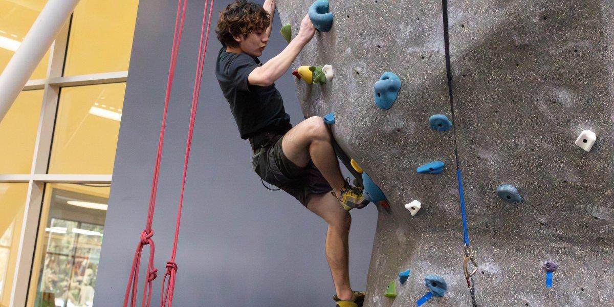 Matthe Menzi小心地把脚放在攀岩墙上的支架上